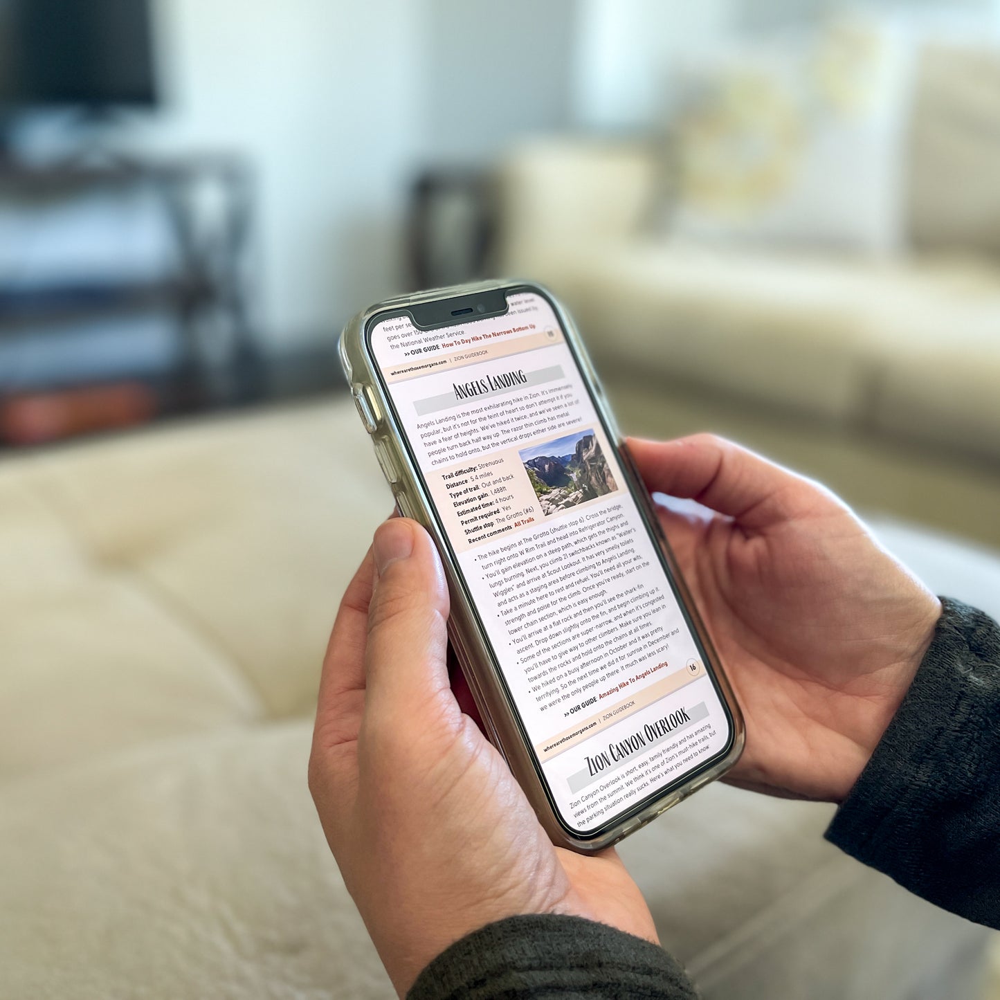 Hands holding a phone displaying a guidebook about Zion National Park.