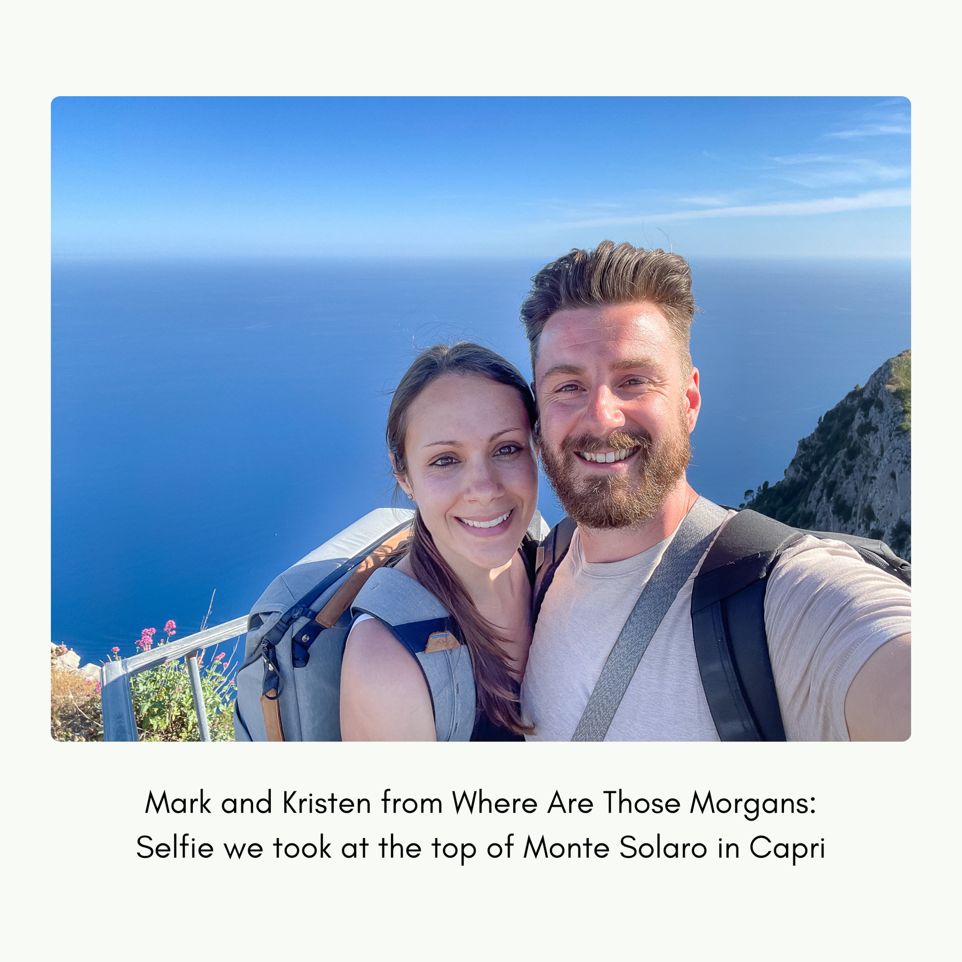Two people taking a selfie at the top of Monte Solaro in Capri with a scenic background.